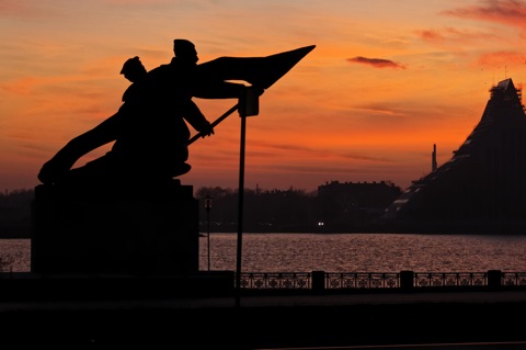 Bild: Denkmal zu Ehren der Revolutionäre des Jahres 1905 in Riga am Ufer der Daugava im Sonnenuntergang.