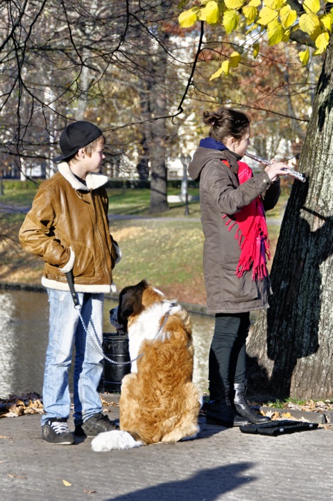 Bild: Junge, Bernhardiner und Mädchen mit Querflöte am Freiheitsdenkmal in Riga.