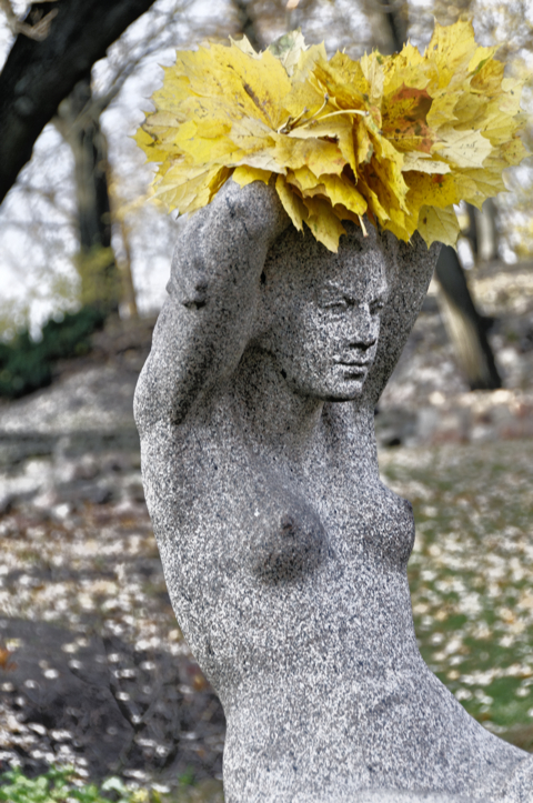 Bild: Blumengeschmückte Statue im Park am Stadtkanal von Riga.