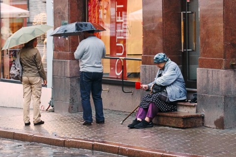 Fototour: Unterwegs an einem regnerischen Sommerabend in der Altstadt von Tallinn. Trotz des Wetters versucht diese ältere Frau, in der Vana Viru ein paar Cent zu bekommen. NIKON D700 und AF-S NIKKOR 24-120 mm 1:4G ED VR.