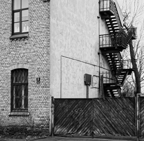 Bild: Feuerschutztreppe an einer Schule in der Sparģeļu iela im alten Arbeiterviertel Grīziņkalns in Rīga. OLYMPUS OM-D E-M1 mit LEICA DG SUMMILUX 25 mm / F1.4. ISO 1600 ¦ f/5,6 ¦ 25 mm ¦ 1/40 s ¦ kein Blitz. Klicken Sie auf das Bild um es zu vergrößern.