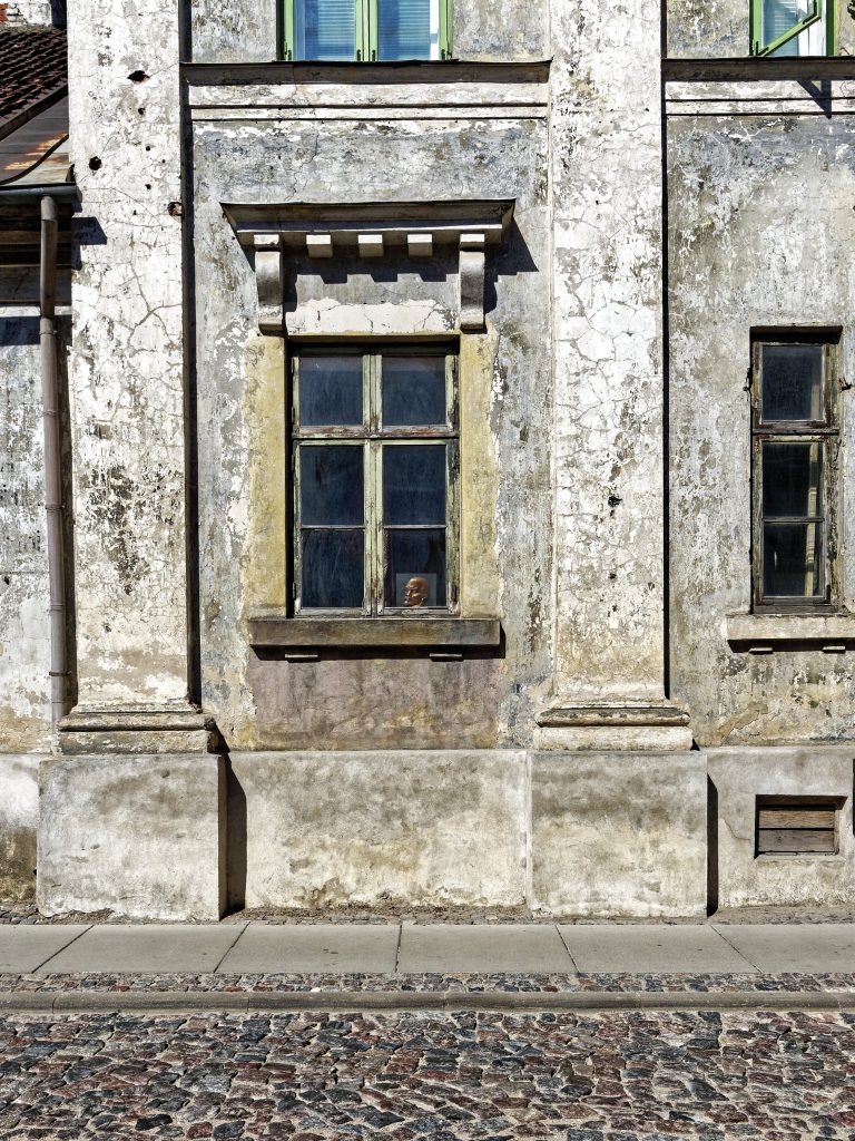 Bild: Manchmal wird man die ungeliebte Geschichte einfach nicht los. Lenin lässt grüßen. In der Altstadt von Kuldīga, Lettland. OLYMPUS OM-D E-M1 Mark II und M.ZUIKO DIGITAL ED 7‑14mm 1:2.8 PRO. ISO 200 ¦ f/5.6 ¦ 12 mm ¦ 1/1600 s ¦ kein Blitz. Klicken Sie auf das Bild um es zu vergrößern.