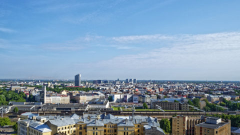 Bild: Ein Blick über das Zentrum von Rīga in Richtung Norden. Im Hintergrund sind mittig die Hochhäuser von Skanste zu sehen.
