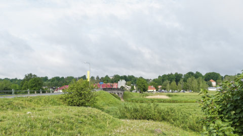 Bild: Blick vom linken Ufer der Abava auf Kandava. Links ist die Steinbrücke zu sehen, rechts der Pulverturm am Rande der Altstadt.